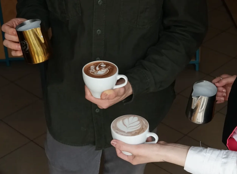 Latte art - bariści pracujący w kawiarni porównują swoje umiejętności.